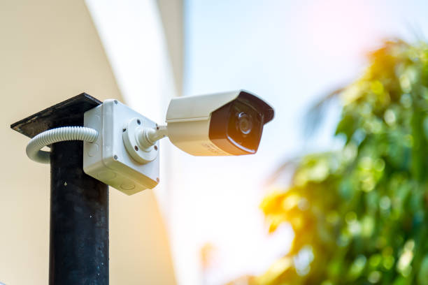 A Wireless CCTV camera setting outside building with white box water poof with sun blur background.